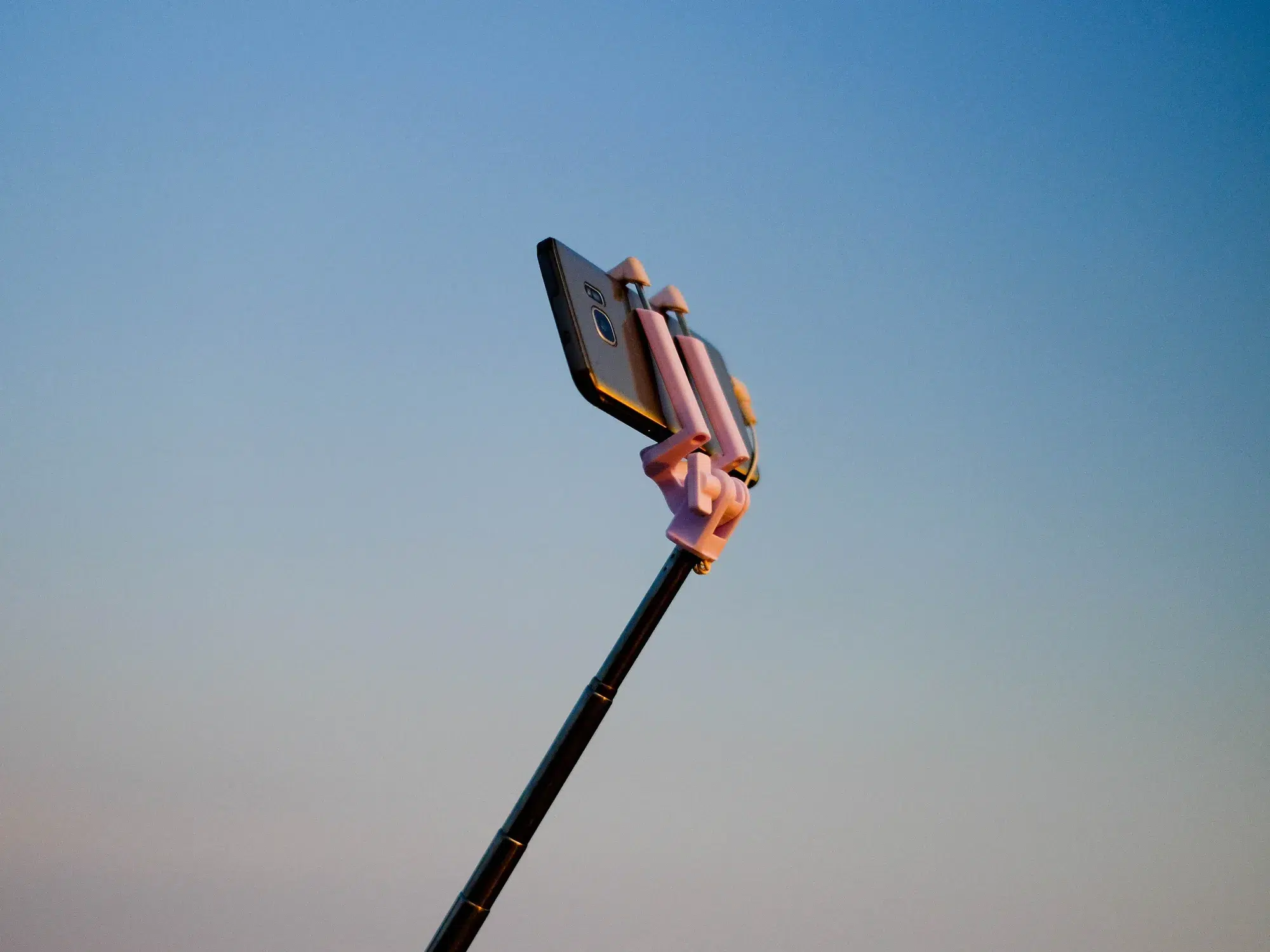​photograph of a smartphone on a selfie stick