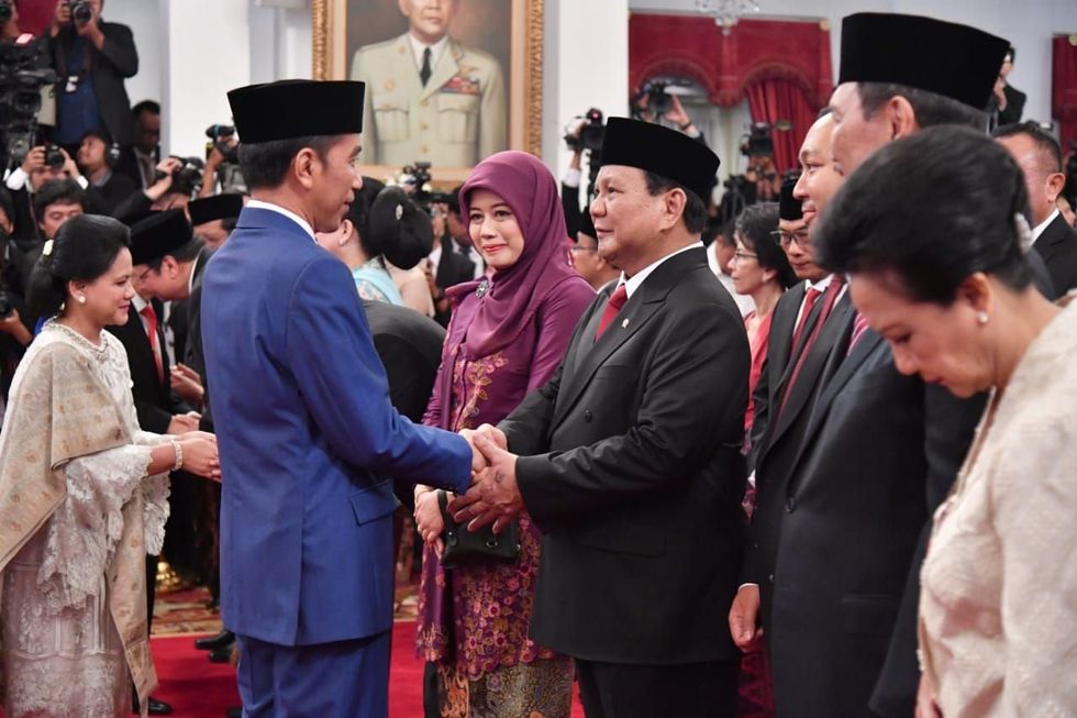 ​President Joko Widodo shaking hands with Prabowo Subianto.
