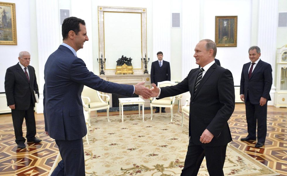 ​President Vladimir Putin greets Syrian President BASHAR ASSAD before their meeting at the Kremlin, Moscow, Russia, Oct. 20, 2015.