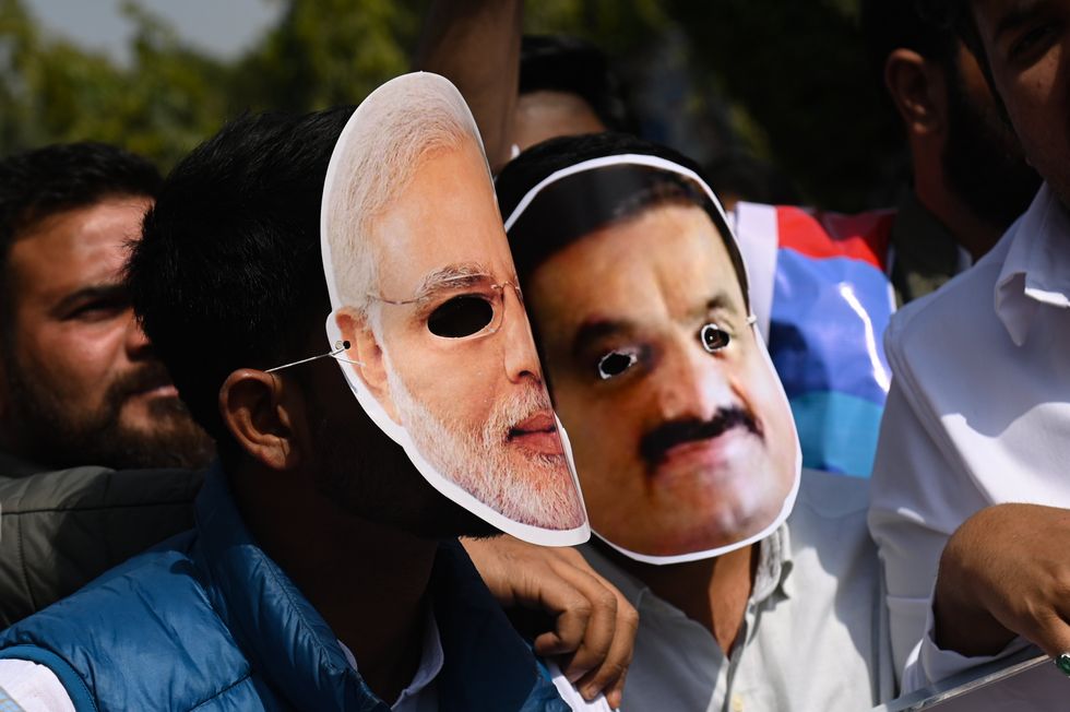 ​Protesters wearing facemasks of Prime Minister Narendra Modi and Indian Businessman Gautam Adani in New Delhi.