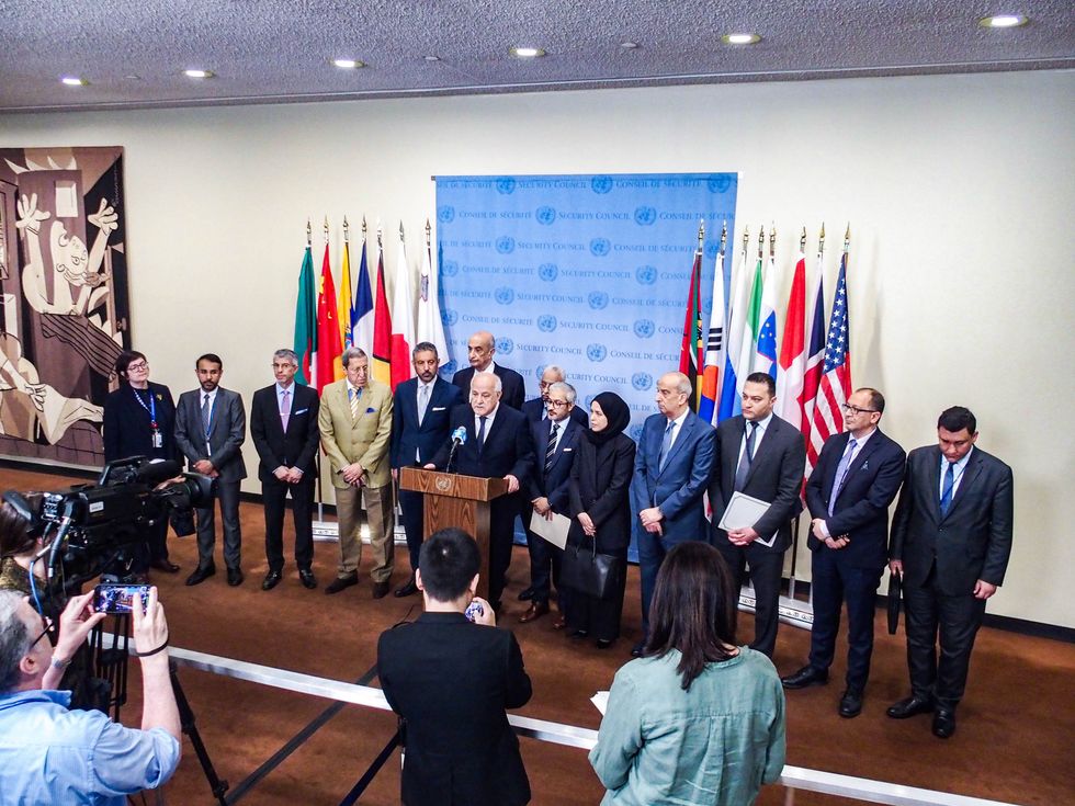​RIYAD MANSOUR, Permanent Observer of the State of Palestine to the UN, briefs reporters while Representatives of the Arab Group stand with him, after a Security Council meeting: Protection of civilians in armed conflict.