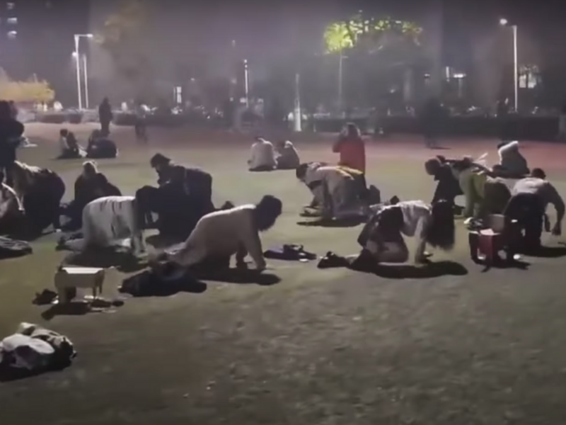 ​Screenshot of a video showing Chinese students crawling on a soccer pitch