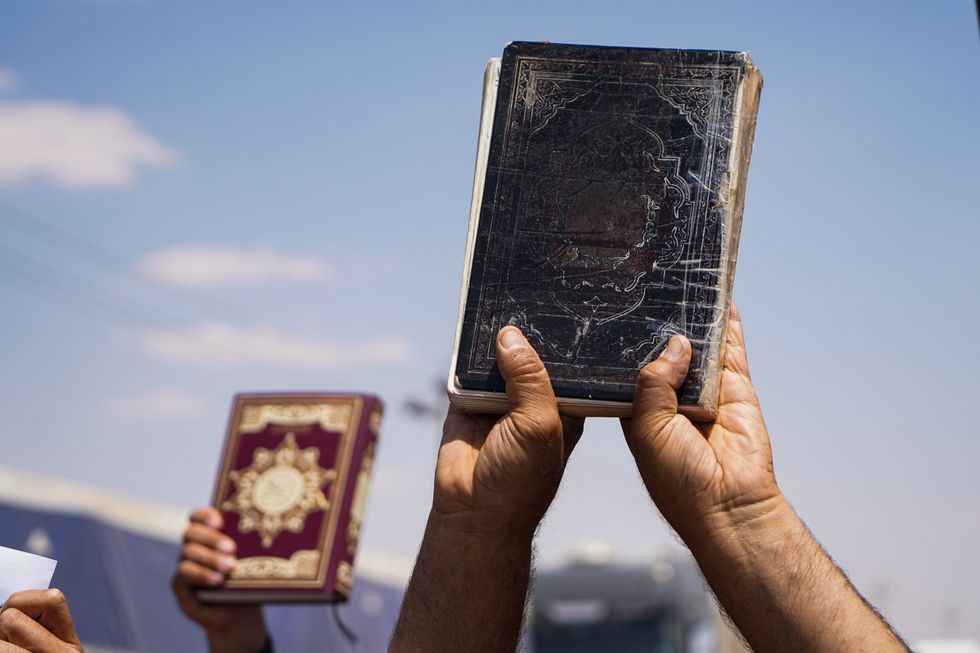 ​Supporters of Iraqi Shi'ite cleric Moqtada al-Sadr, hold Koran during the demonstration near al-Hamdaniya.