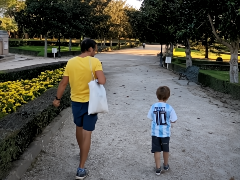 ​The author and his child, Lorenzo, walking down a path together.