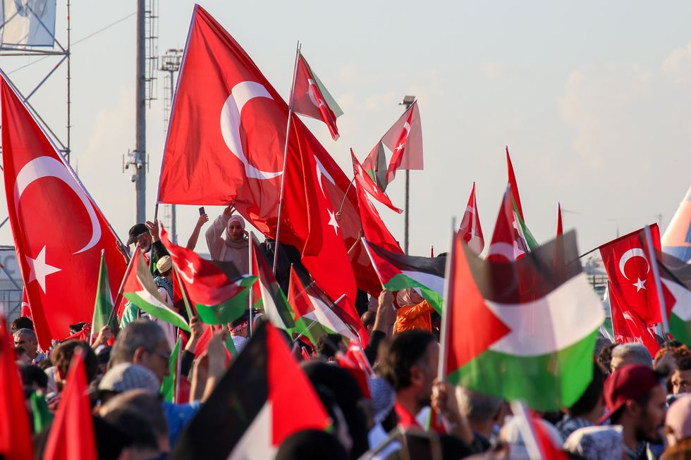 ​The Great Palestine Rally, plent of people gathered around with flags of Turkey and Palestine.