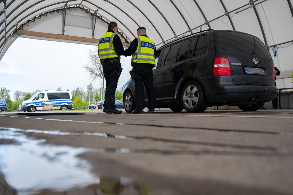 ​Two Federal Police officers check a black car on its way to Germany in Ludwigsdorf.
