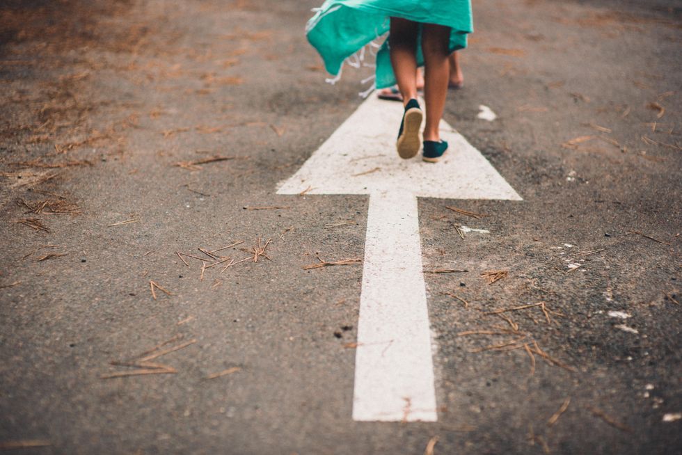 ​Woman walking on an arrow on a street