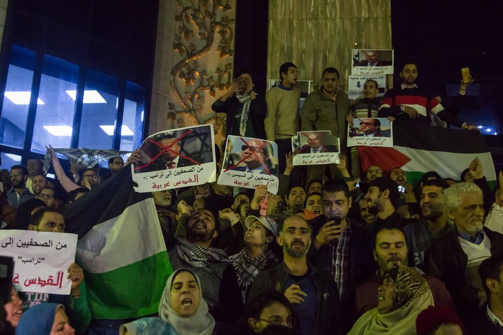 Egyptian protesters hold a portrait of Egyptian President Abdel Fattah al-Sisi and US president Donald Trump and Israeli Prime Minister Benjamin Netanyahu during a demonstration against the US president's recognition of Jerusalem as Israel's capita