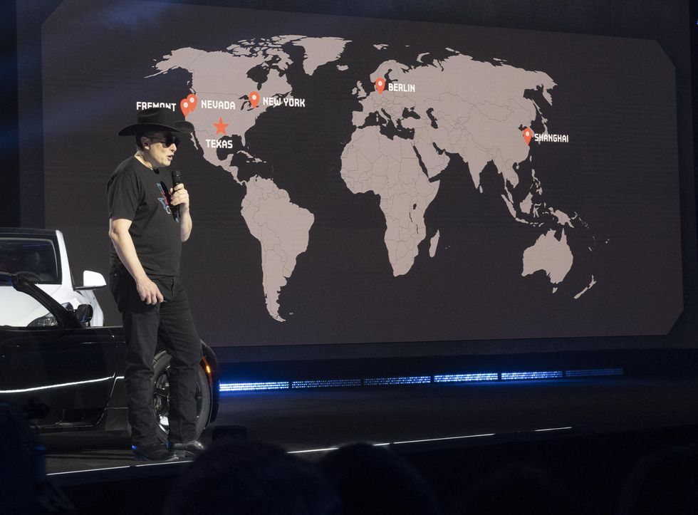 Elon Musk speaking in front of a map of the world.