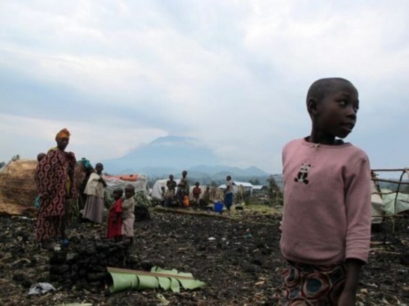 Families look on in the Kanyaruchinya camp