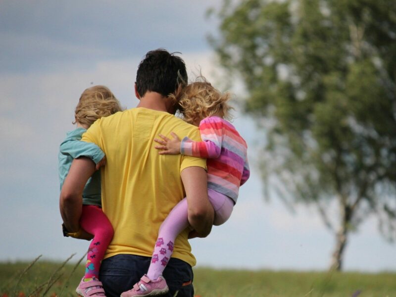 Father carrying his daughters.