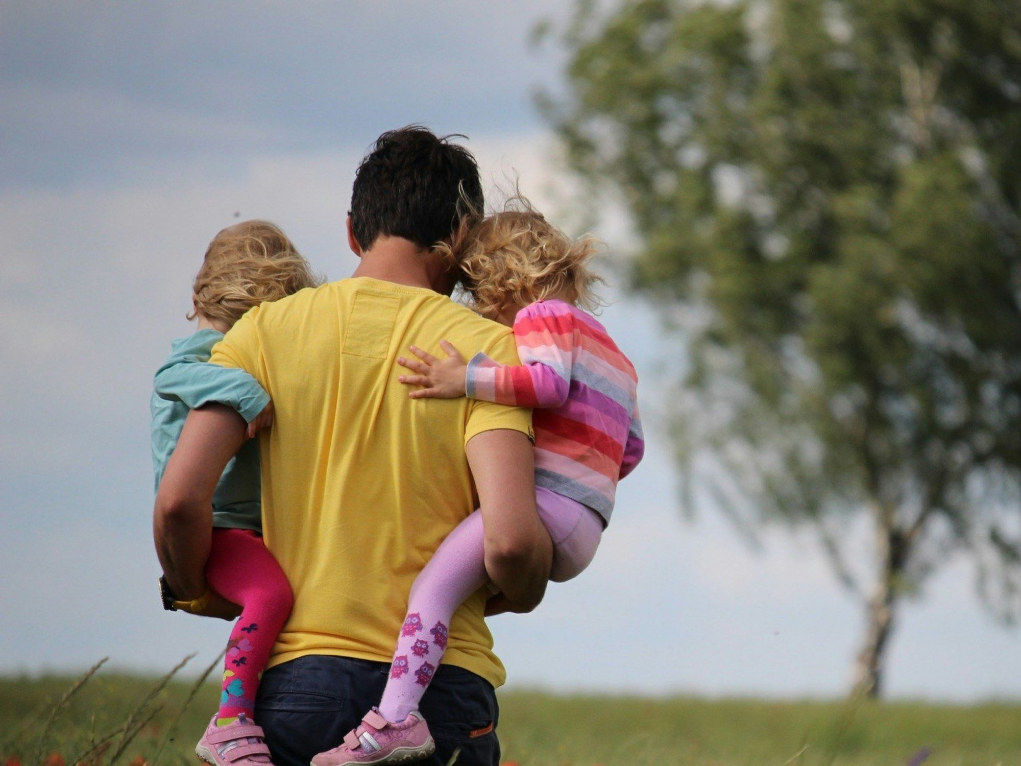 Father carrying his daughters.