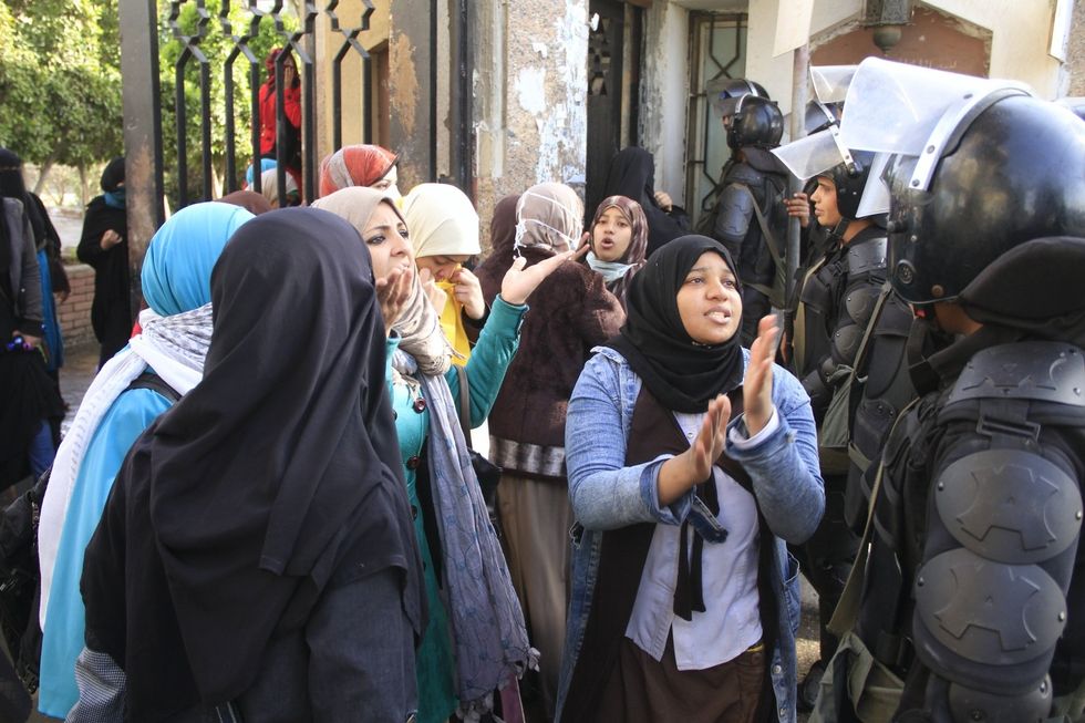 Female Islamist students speak to police during a protest.