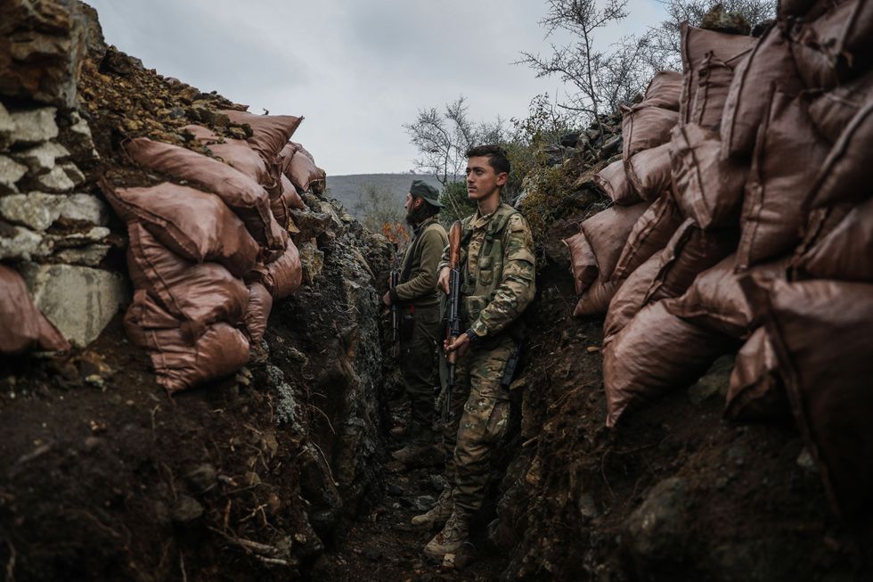 Fighters standing in the trenches in Latakia, Syria.