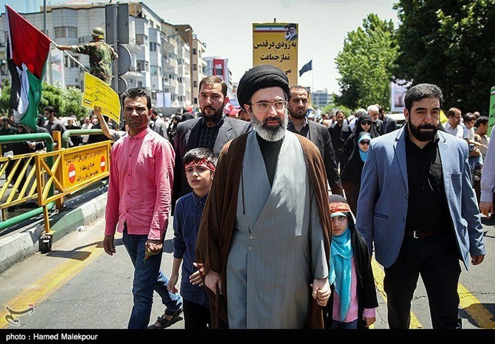 File photo of Mojtaba Khamenei walking with his children in Tehran