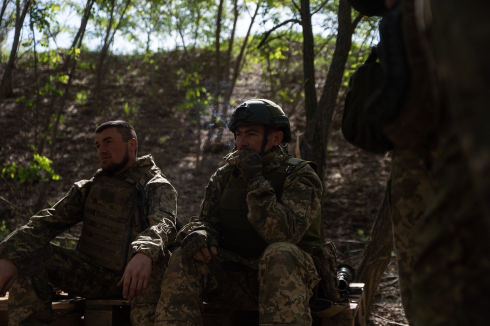 File photo of three Ukrainian soldiers taking a break on the frontlines near Kyiv in May 2024.
