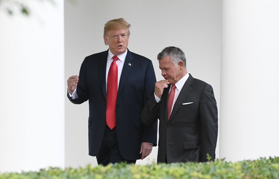 File photo of U.S. President Donald Trump and King Abdullah II talking as they walk near the White House during the King's visit to the White House, in 2018.