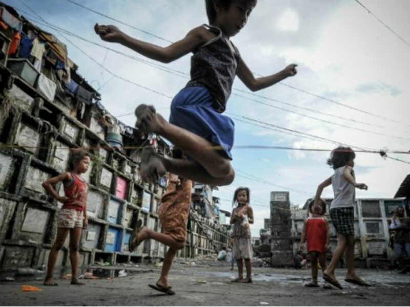 Filipino children playing in a cemetery near Manila as the country prepares for All Saint's Day