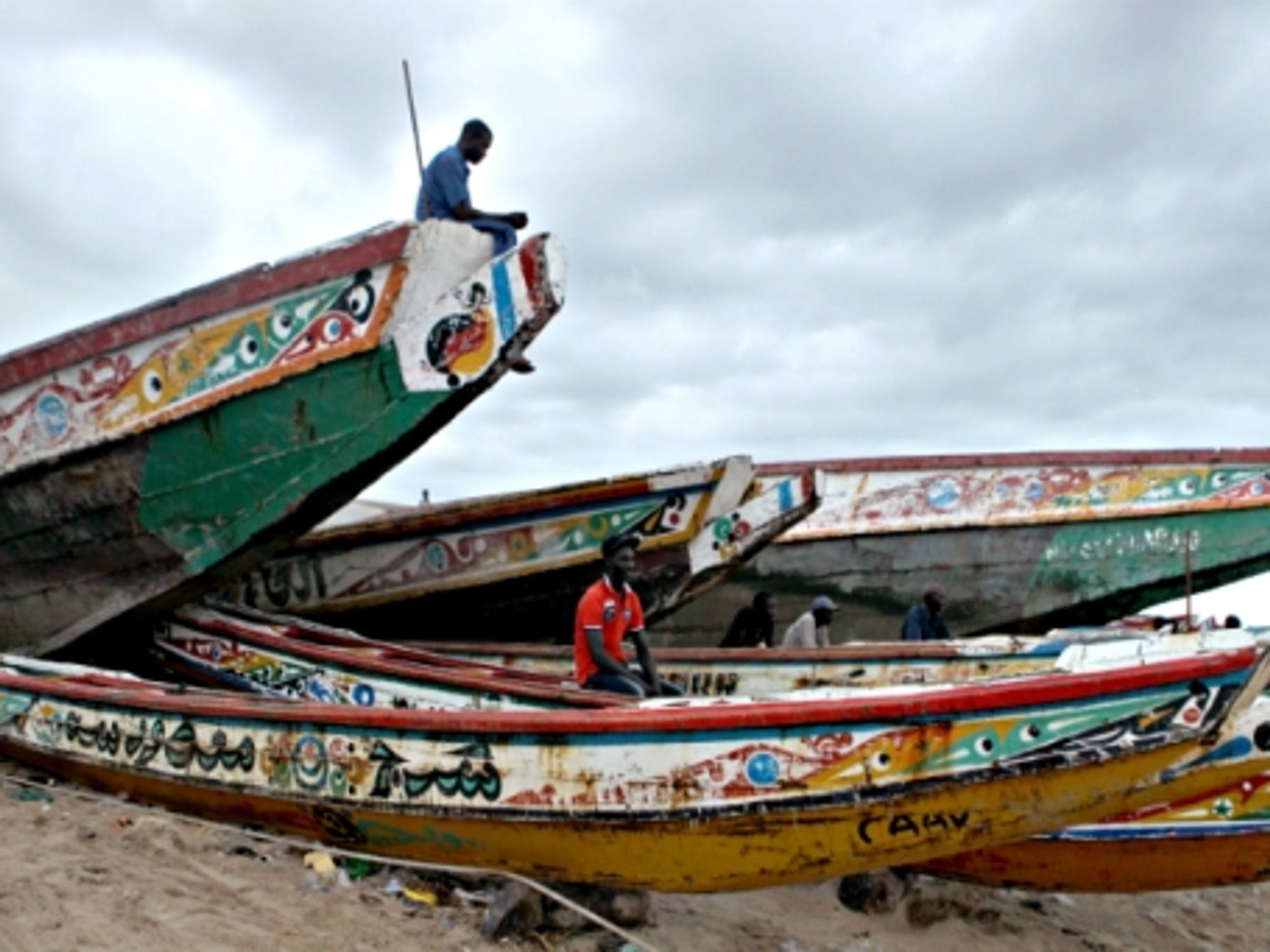Fishermen wait on boats at a fish market in M'bour, Senegal