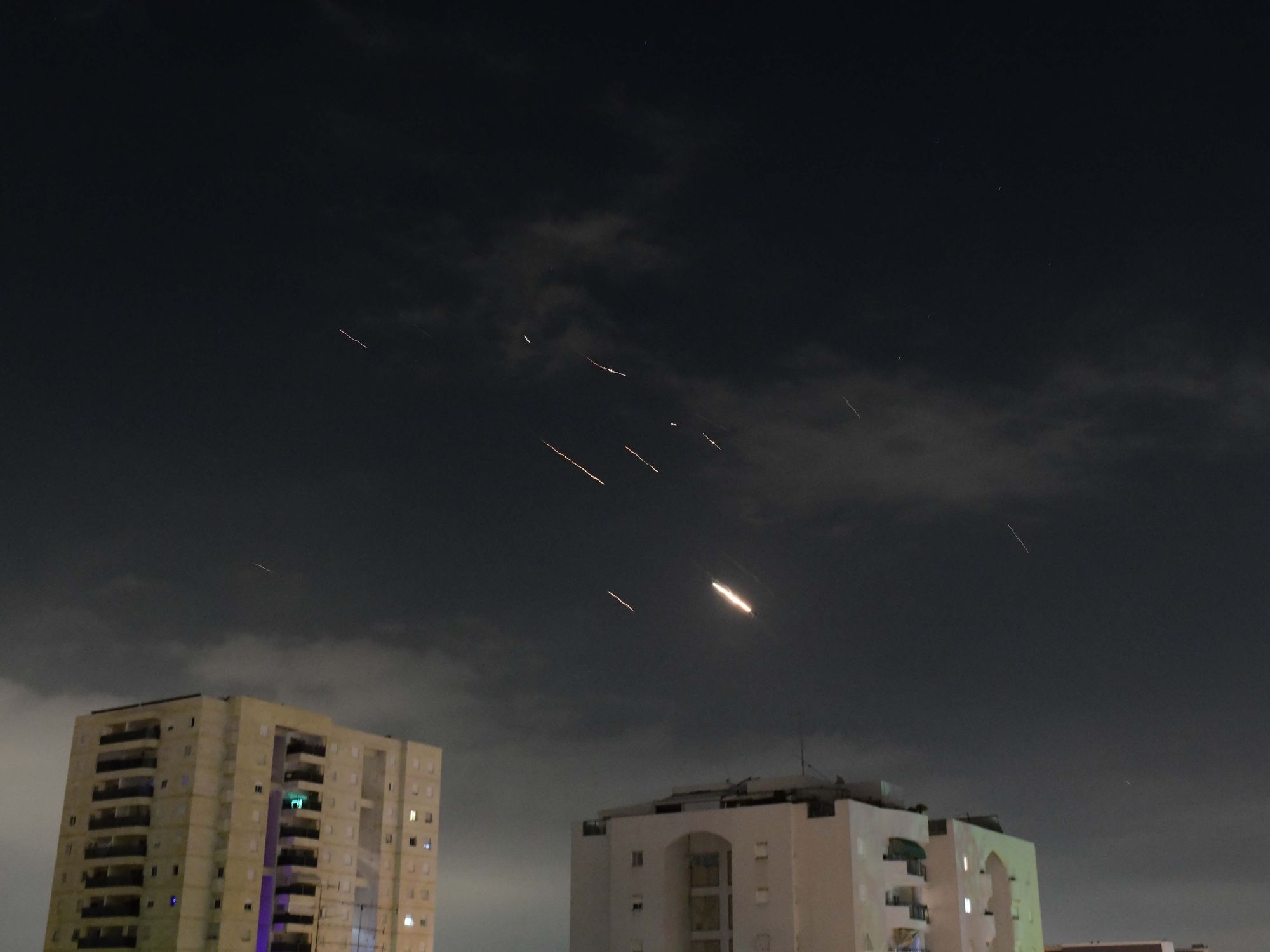 Flares from ballistic missile and drone explosions over Tel Aviv.