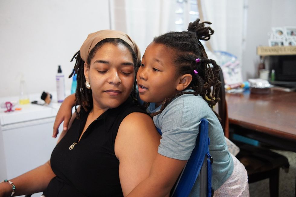 Flor-Angel Guilbe Stevens, left, and her daughter, Perla del Mar, share a tender moment at home in Juana Díaz. Guilbe acknowledges that she didn't visibly recognize herself as black in her youth, but she values and feels proud that her daughter does.