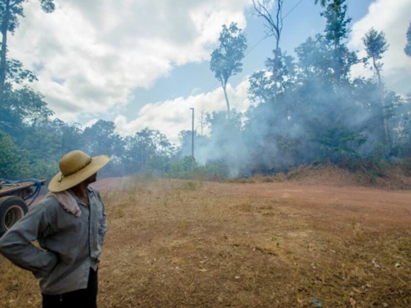 Framer Ita watches as smoke rises from a fire in the Amazon Rainforest