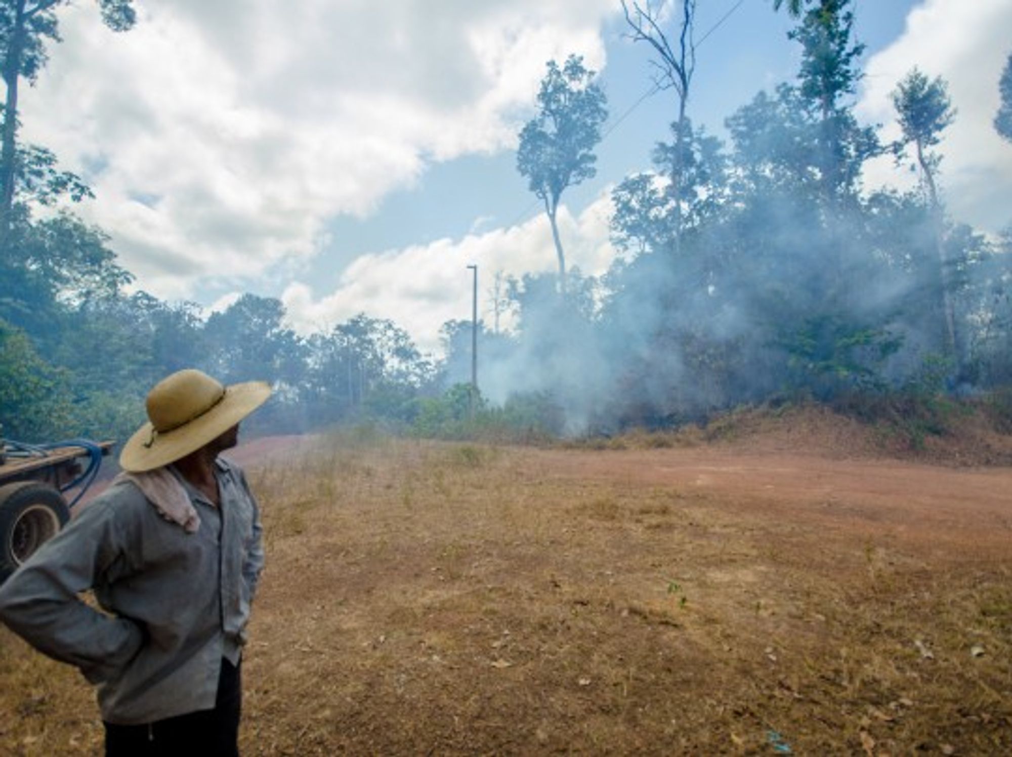Framer Ita watches as smoke rises from a fire in the Amazon Rainforest