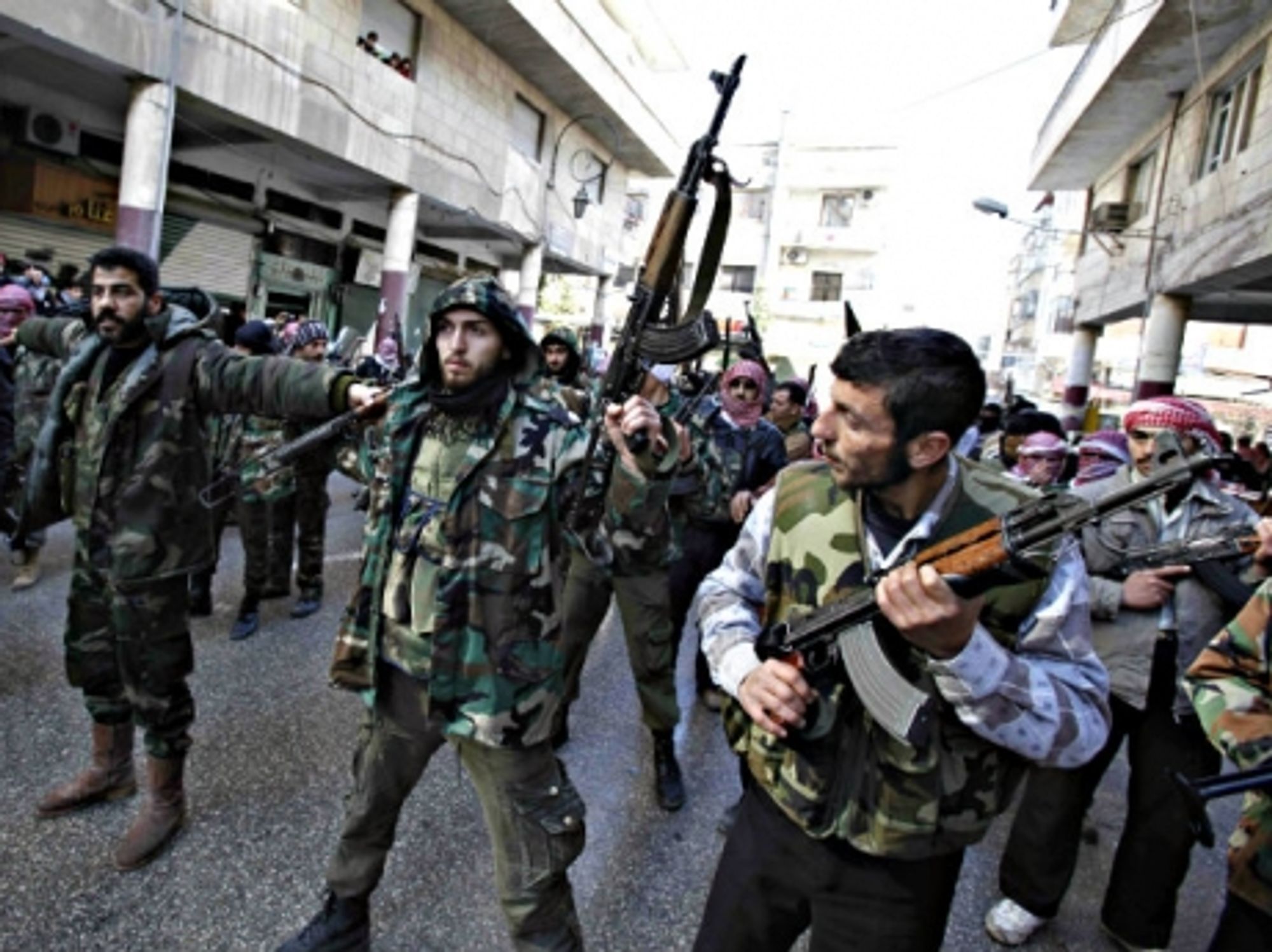 Free Syrian Army (FSA) fighters marching through the streets of Idlib