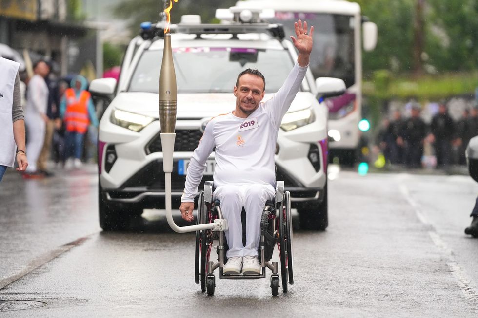 French athlete ​David Toupé carrying the Olympic flame.