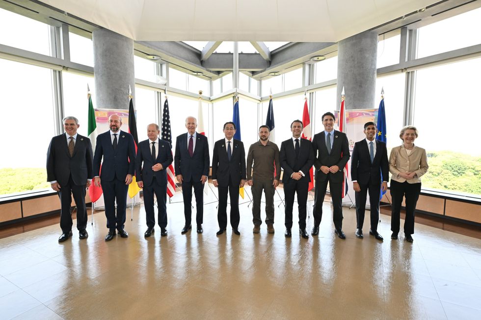 G7 leaders and Ukraine’s President Volodymyr Zelensky line up infront of their flags.