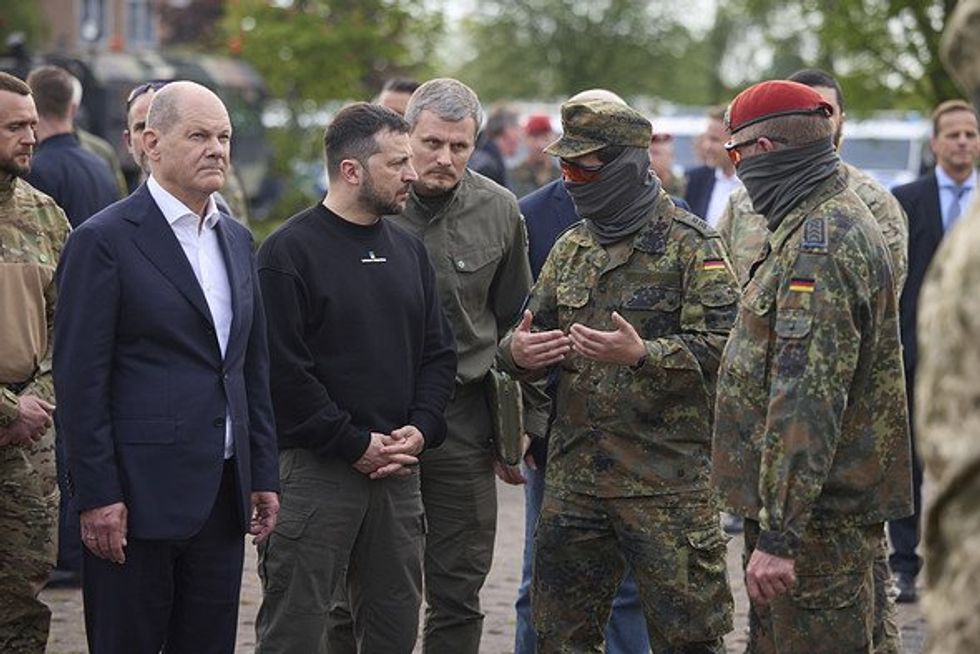 German Chancellor Olaf Schotz, left, and Ukrainian President Volodymyr Zelenskyy, center, watch a demonstration during a visit to Camp Aachen.