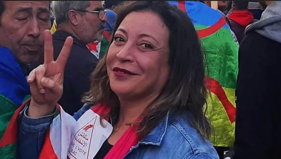 Ggynecologist and activist Amira Bouraoui doing a V sign with her fingers at a rally