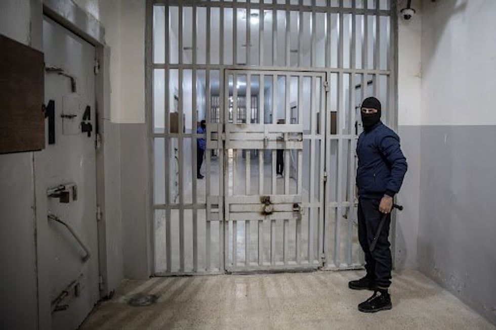 Guards in balaclavas stand outside cells in Panorama prison in southeast Syria, where men accused of affiliation to the so-called Islamic State have been locked up for years.