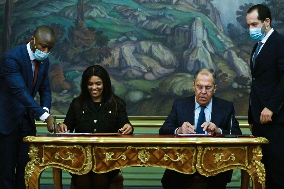 Guinea-Bissau and Russia's Ministers of Foreign Affairs sign papers seated at a guilded desk