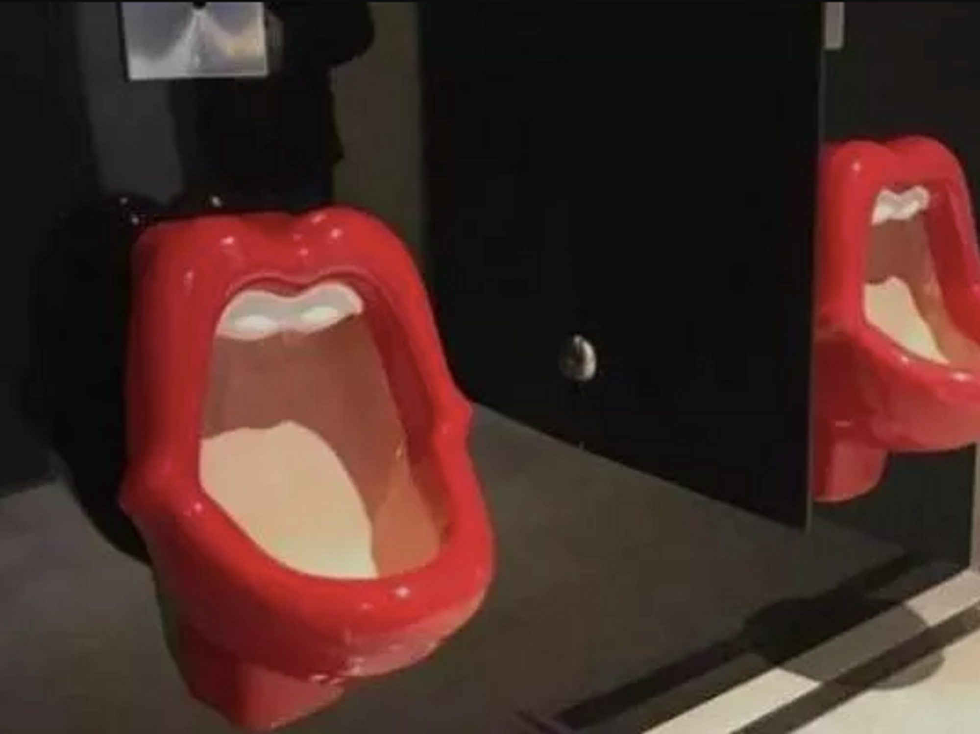 Gym's urinal shaped like a woman's mouth.