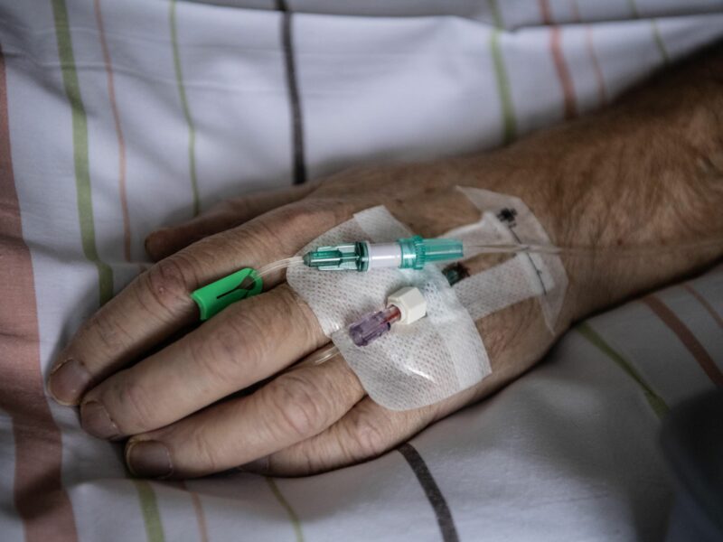 Hand of a patient with severe corona in an intensive care unit