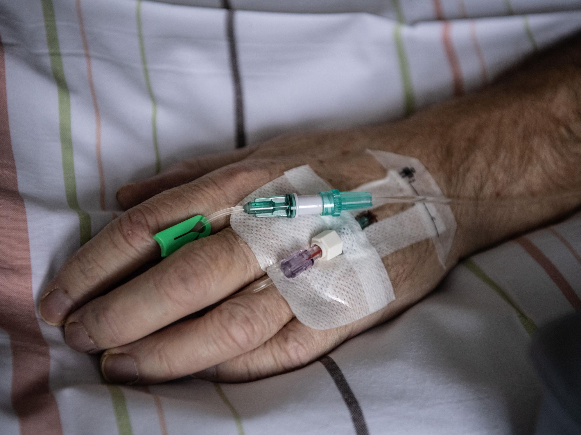 Hand of a patient with severe corona in an intensive care unit