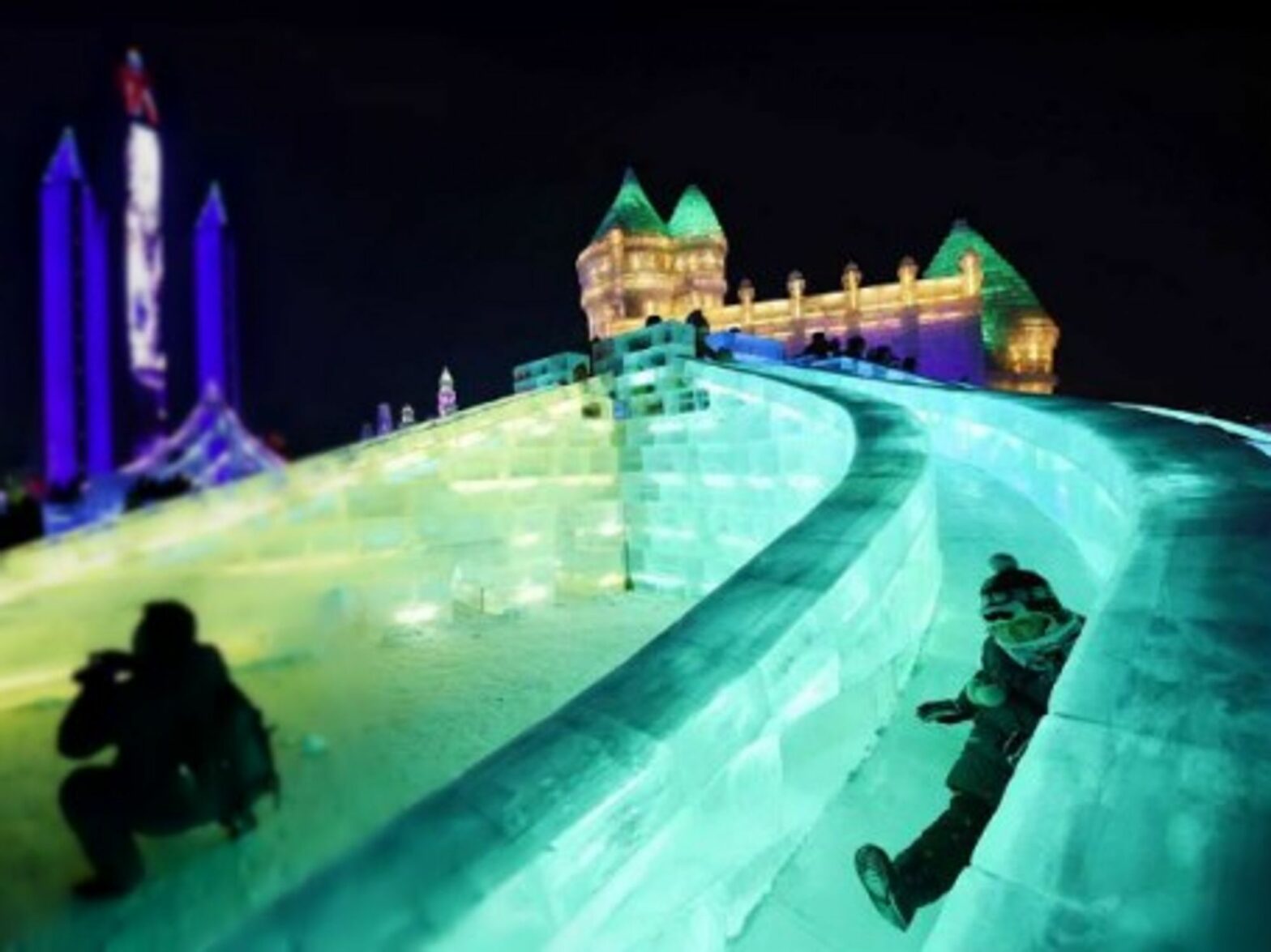 Having fun on ice slides Monday at Harbin's Ice and Snow World in northeastern China.