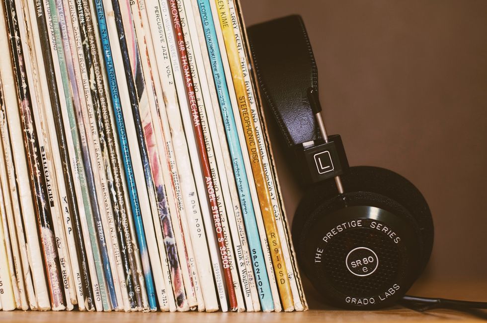 headphones leaning against vinyls on a shelf