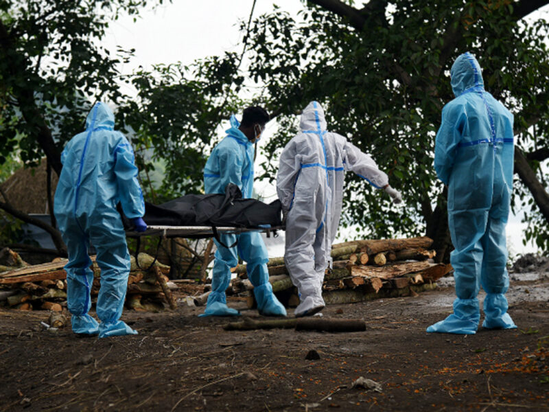 Health workers carrying a dead body in India