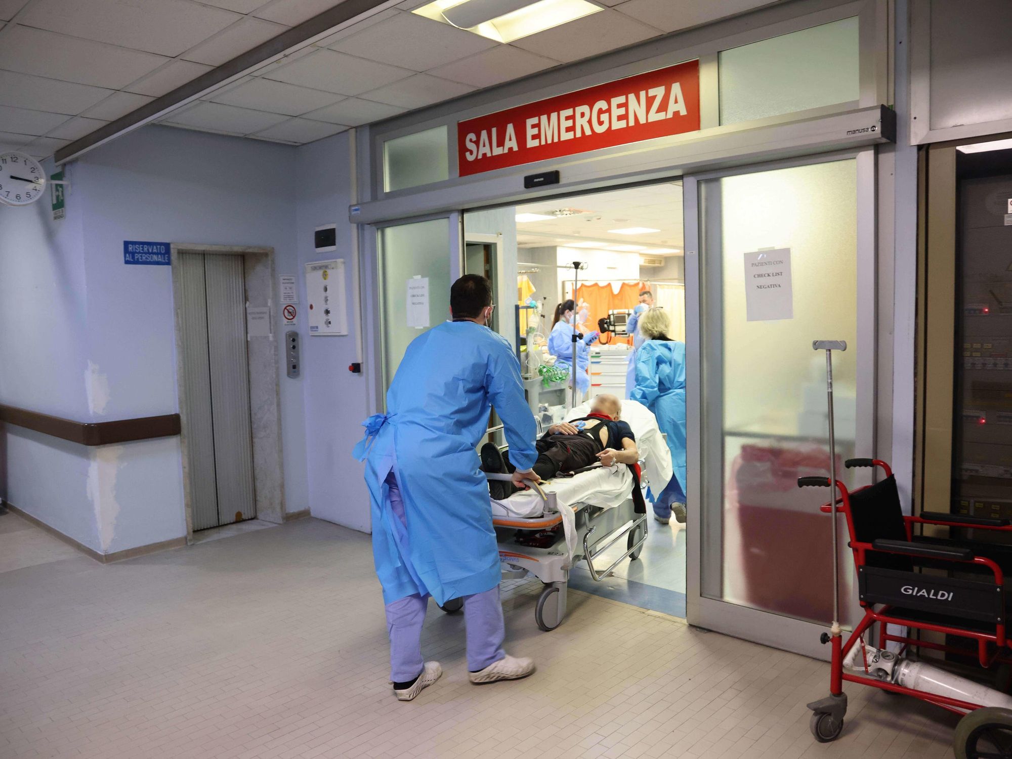 Health workers wearing overalls and protective masks at work in the intensive care unit of the hospital of Cremona