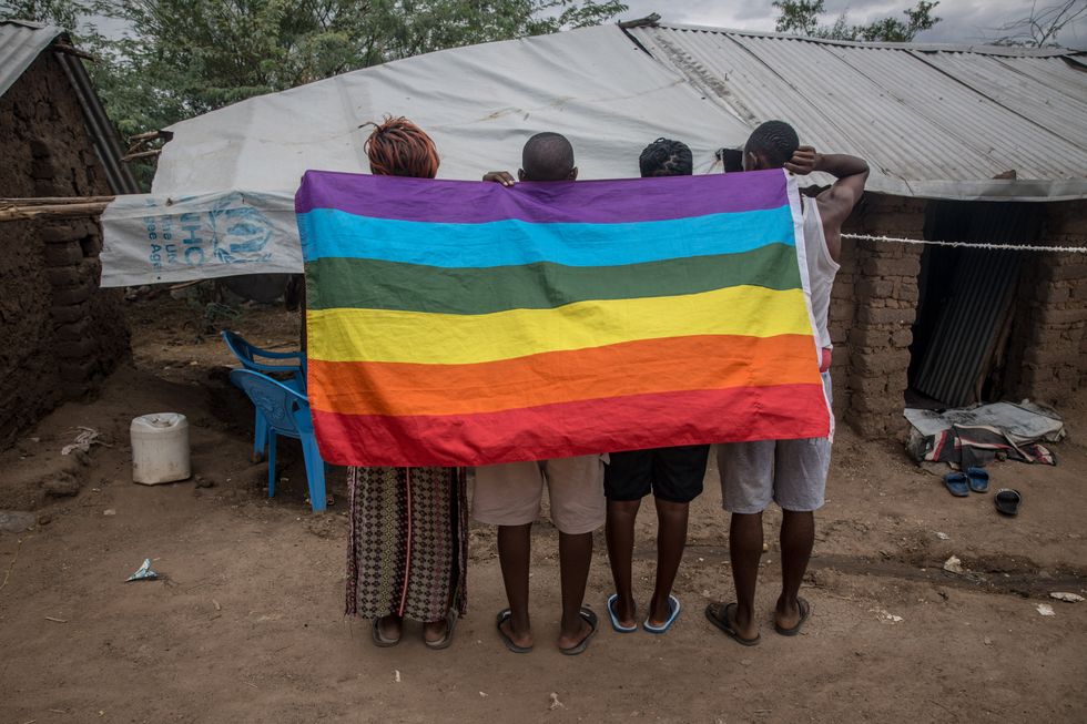 image of 4 people holding a rainbow LGBTQ flag