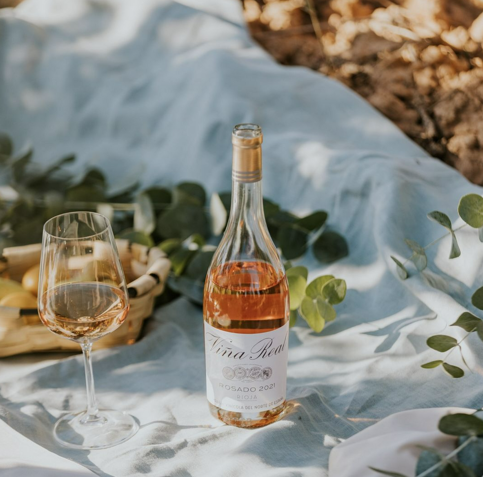 Image of a bottle of Viña Real rosé, with a glass full of wine next to it.