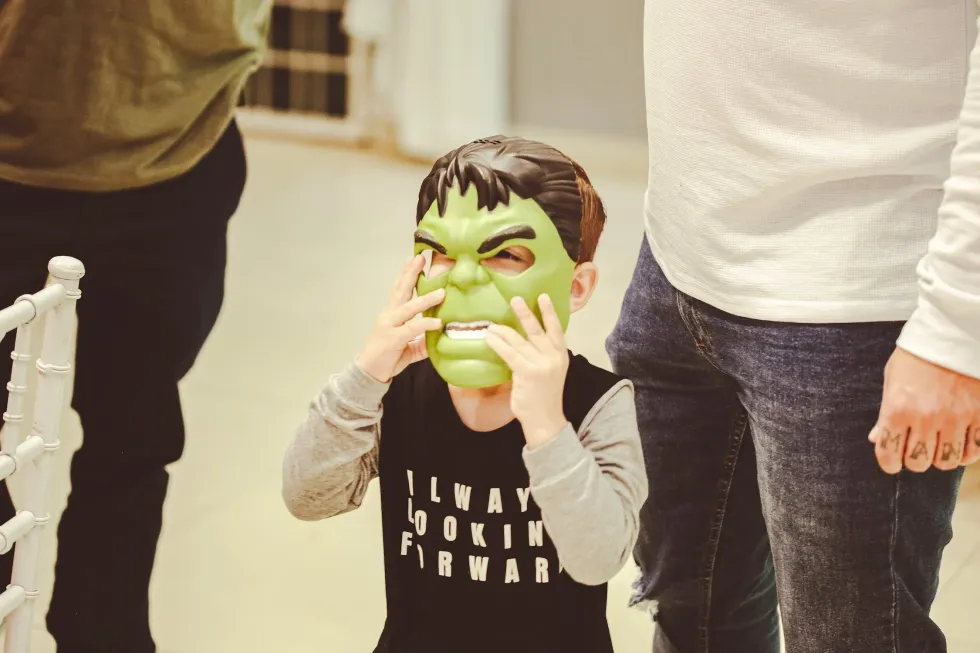image of a boy putting on a hulk mask