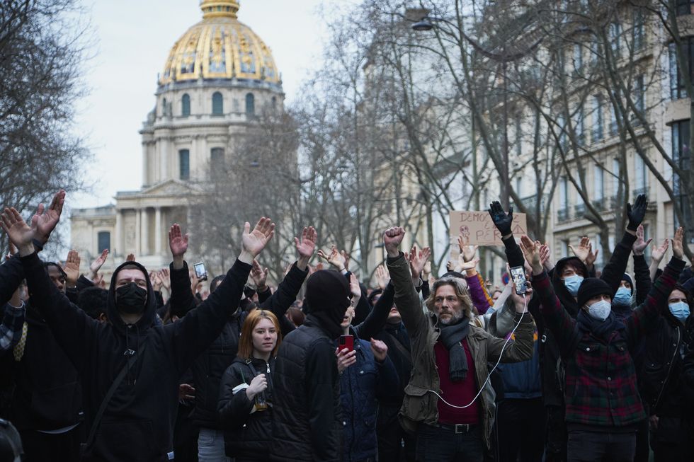 Image of a crowd of protesters in Paris holding out their hands
