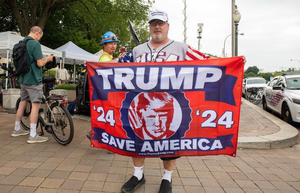 Image of a fan in Florida holding a flag in support of former president Donald Trump