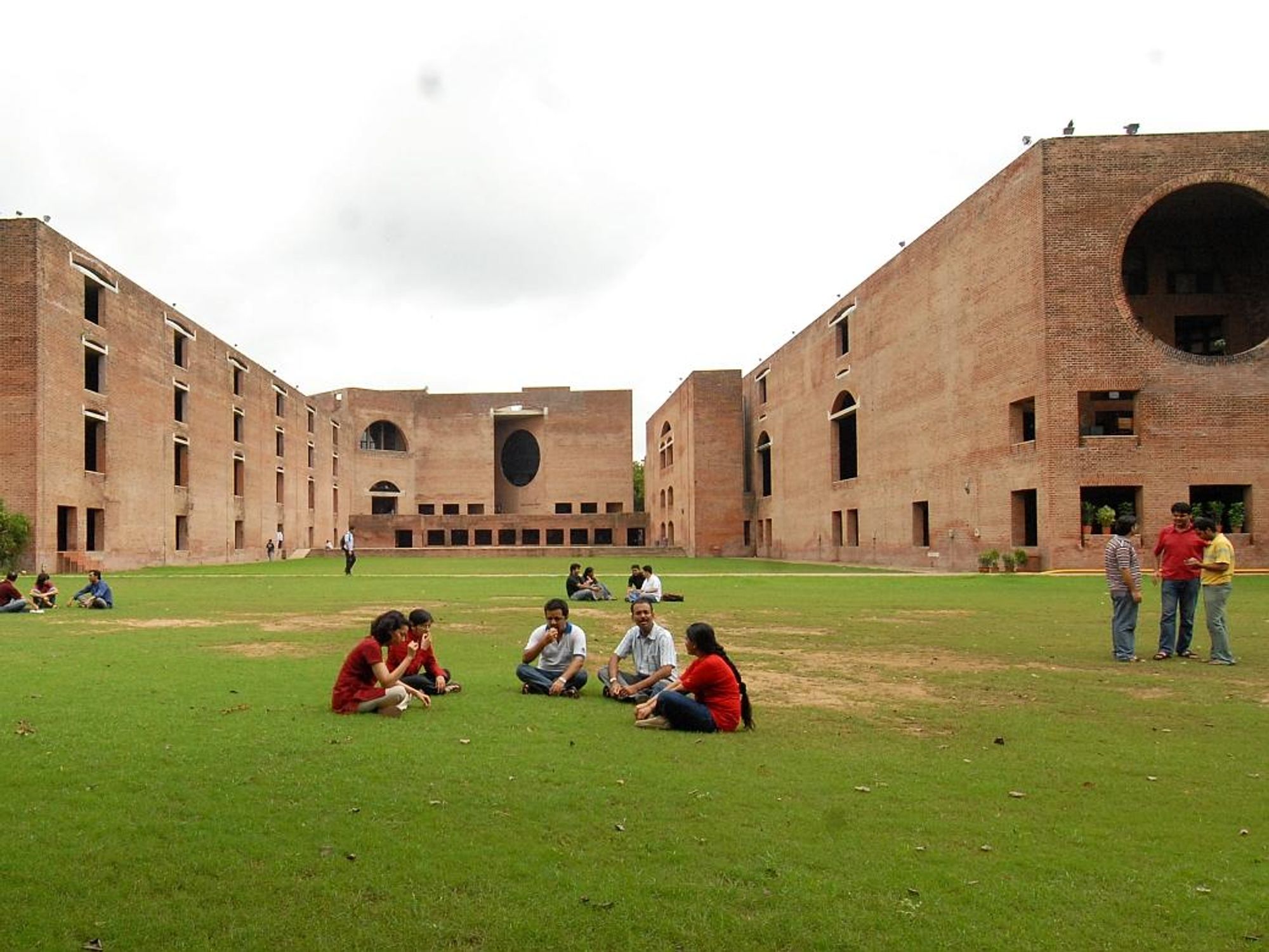 Image of a group of five people sitting on the grass inside of the Indian Institute of Technology campus.