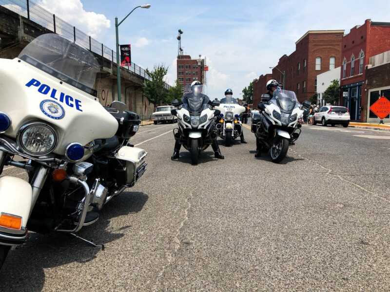 Image of a group of police officers, in uniform, on their motorbikes in the street.