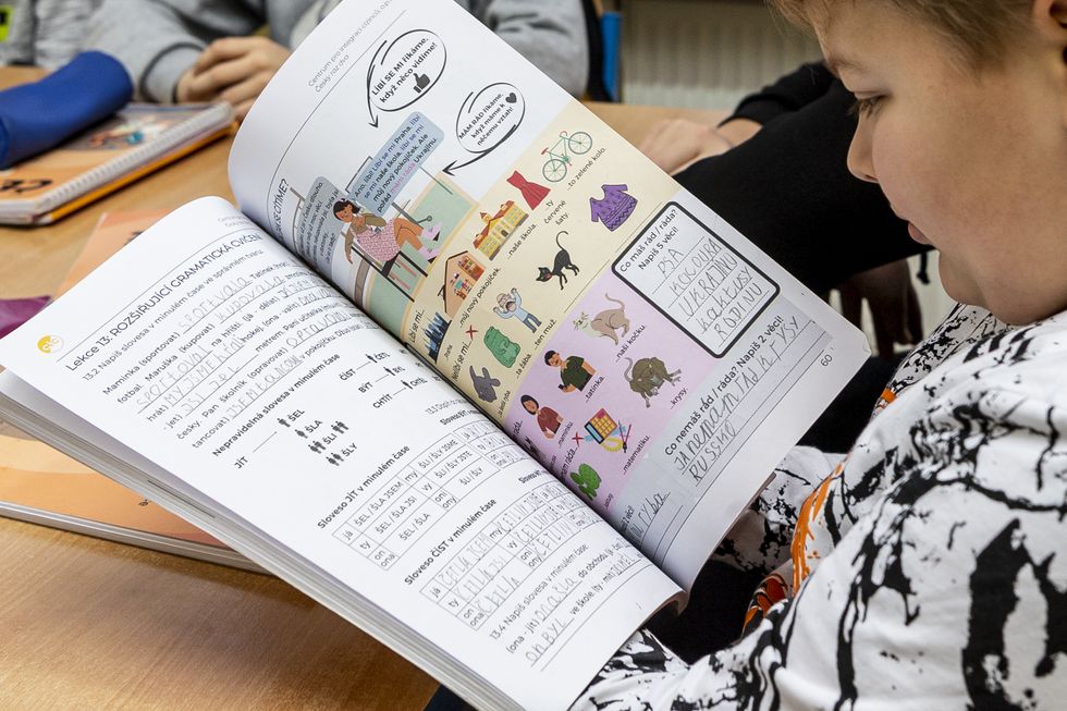 Image of a kid holding a text book.