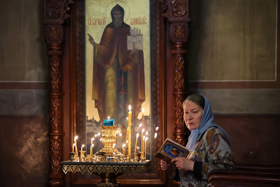 Image of a lady in a church holding a prayer book